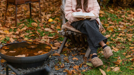 Woman reading a book outdoors on a crisp autumn day