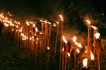 Line of Burning Torches in the Night – Warm Light Ceremony Honoring Freedom, Unity, and...