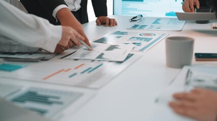 A group of diverse professionals collaborates in a modern office environment, focused on analyzing data visualizations with charts and graphs for informed business strategies. SACTR - Powered by Adobe