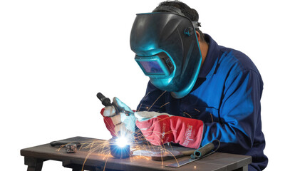 A skilled welder in blue coveralls and safety gear performs metalwork, creating bright sparks with a welding torch on a work table. background removed