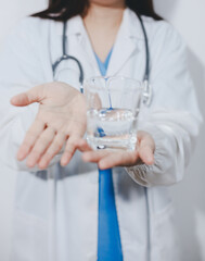 Portrait of Asian doctor woman standing holding coffee cup in white studio background
