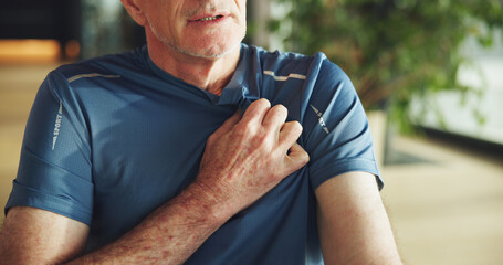 Hand, chest pain and senior man in home with emergency, hypertension or sickness in living room....