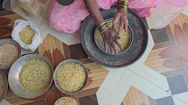 A metal sieve (chalni/strainer) cleans pulses. Shaking it allows smaller dirt/impurities to fall through holes, leveraging size differences to ensure grains are clean for cooking. Winnowing separation