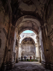 Ruins of Time: An evocative shot of ancient architecture, evoking a sense of history and the passage of time. A group of observers gathers under the remnants of a roof.