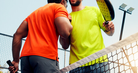 Men, athletes and handshake for padel, court and respect for opponent, sportsmanship or competition. Outdoor, tennis players and hug for friendly match, greeting and people with racket and low angle