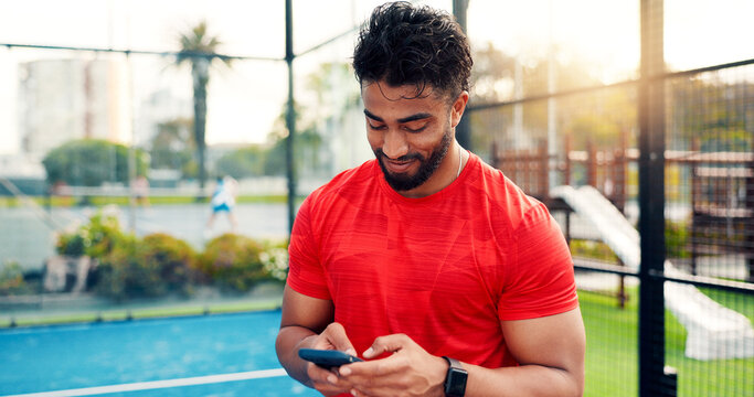 Smile, man and reading with phone on tennis court with fitness app, training tips and track progress. Person, mobile and reservation for padel, technique and video demonstration of tournament results