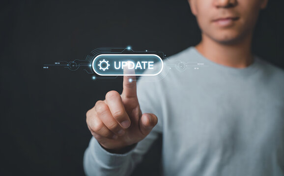 Mans finger pressing a glowing update button on a futuristic interface, signifying software updates, system changes, and technological advancement