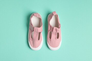 Pair of stylish kid's shoes on turquoise background, top view