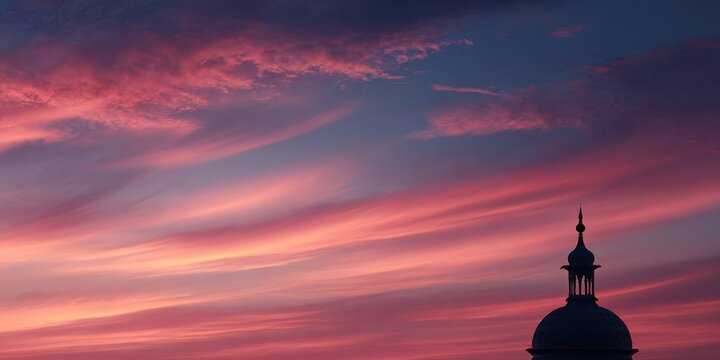 Dramatic sunset sky over the city with vibrant pink and purple clouds and silhouette of a building dome