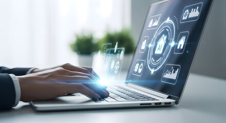 Close up of hands typing on a laptop displaying a futuristic digital interface with icons