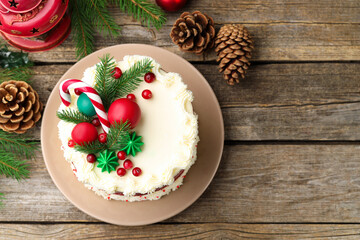 Tasty cake with Christmas decor on wooden table, flat lay. Space for text