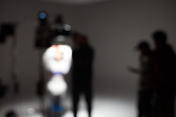 Out of focus studio with lighting and people working on the set.