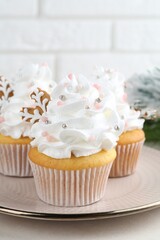 Tasty cupcakes with Christmas decor and gingerbread cookies on white table, closeup