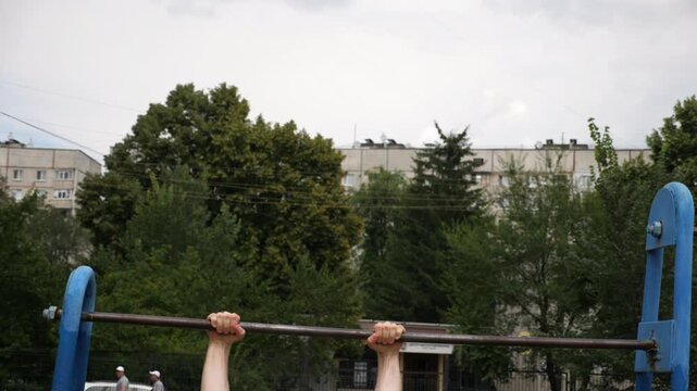 Sportsman performing dynamic workout routine on parallel bars, showcasing strength and control through a series of fluid movements, emphasizing athleticism and dedication to fitness training