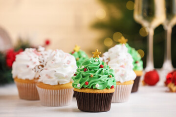 Tasty festive cupcakes on white table, selective focus. Christmas treat