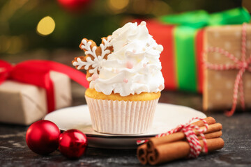 Festive cupcake with cookie, cinnamon and christmas decor on black table, closeup