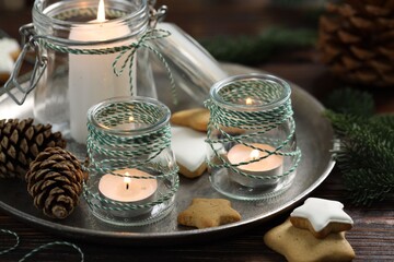 Christmas lanterns, cookies and festive decor on wooden table, closeup