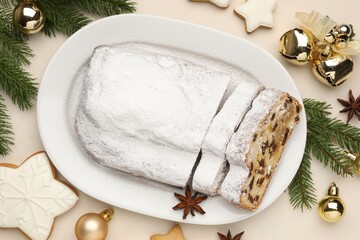 Cut traditional Stollen cake, cookies and Christmas decor on white table, flat lay