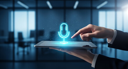 Hand interacting with a holographic microphone icon on a tablet in an office environment.