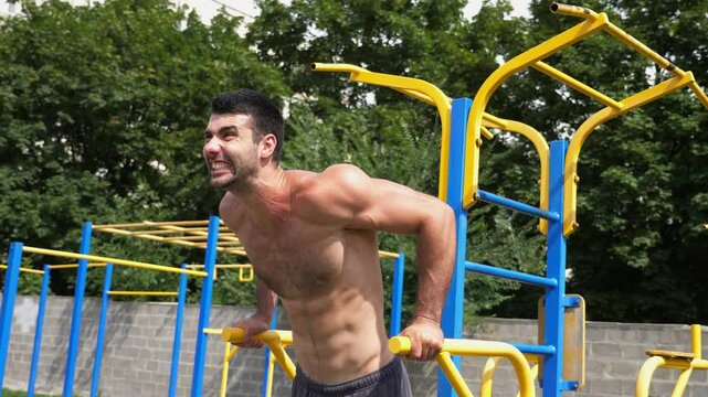 Sportsman performing intense workout on parallel bars, showcasing strength and determination through dynamic movements emphasizing muscular engagement and athleticism in a vibrant training environment