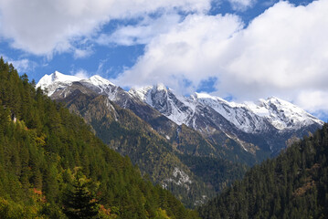 snow mountain under blue sky with white clouds in sunny afternoon