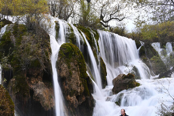 view of white waterfall on the rocks in the forest