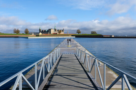 bridge over the river thames Shows a pier extending into water with a distant castle. Full-frame composition, blue-gray tone. Realistic style, coastal background