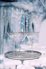 Two elegant martini glasses with crushed ice on a silver tray in a festive winter-themed setting. Holiday celebration styling, Christmas entertaining, minimal luxury decor, frosted seasonal aesthetic
