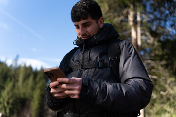 Man hiking navigating smartphone in forest nature outdoors