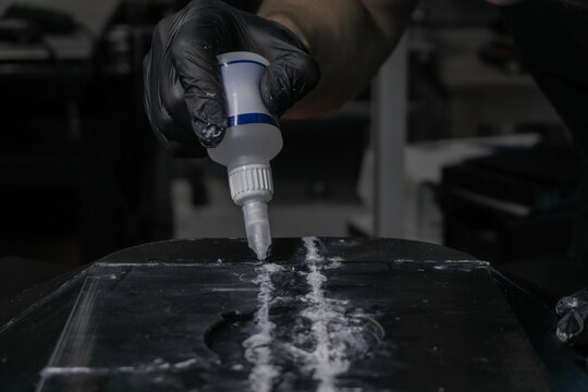 Precision assembly of 3D printed parts using cyanoacrylate glue. The adhesive is carefully applied with a syringe for strong bonding in hard-to-reach areas, showcasing DIY craftsmanship.
