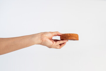 Chocolate round donut in hand on white background