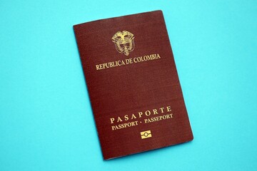 Colombia Republic red passport on light blue table background close up. Concept of travel and tourism