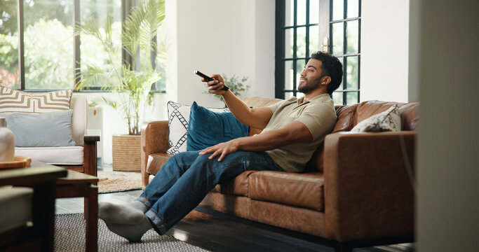 Relax, watching tv and man with remote on couch, streaming subscription or movie selection choice. Press, film website and person in home for entertainment, channel surfing or search with controller