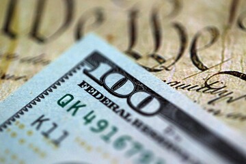 One hundred US dollar bills and United States Constitution page fragment. Concept of lawsuit and...