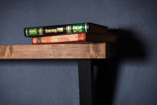 Modern wall shelf with design. Decorative wooden and metal shelf on a dark wall. Designer diamond-shaped wall shelf in loft style