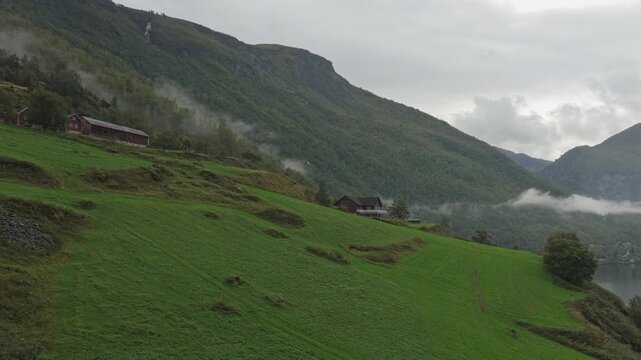 Drone shot of Otternes bygdetun village along moody fjord shores in scenic western Norway