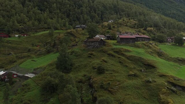 Old rural village Otternes on fjord edge in Norway during overcast day, aerial footage