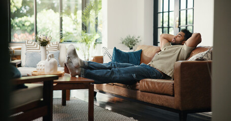 Nap, relax and man on sofa with stretching, stress relief and resting on weekend break. Peaceful,...