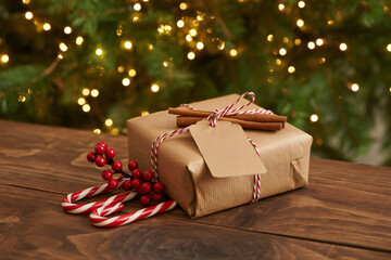 Brown Christmas gift box with a blank tag on rustic wooden table.