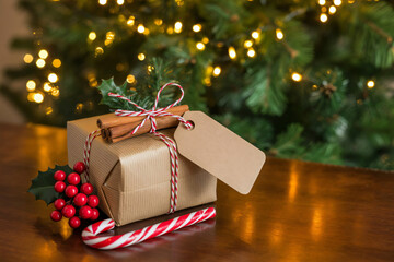 Brown Christmas gift box with a blank tag on rustic wooden table.