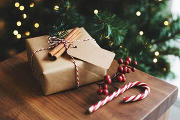 Brown Christmas gift box with a blank tag on rustic wooden table.