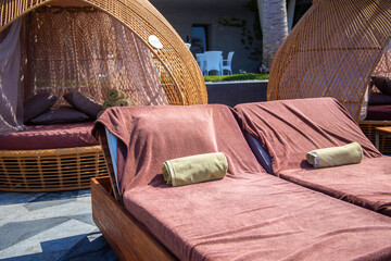 Luxury sun loungers with towels on the hotel beach have been prepared for hotel guests. Beach loungers with soft cover