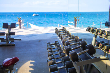 Outdoor gym with sea views. Dumbbells lying in a row on the outdoor gym
