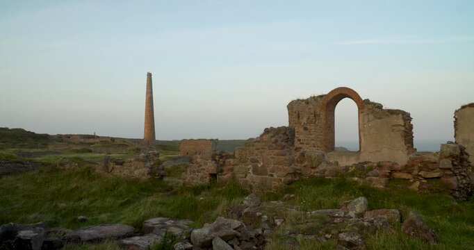 Old stone ruins of engine houses at Botallack mines on the Atlantic coast of Cornwall, England, UK during golden hour at sunrise