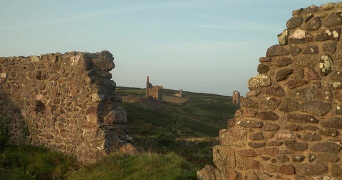 Old stone ruins of engine houses at Botallack mines on the Atlantic coast of Cornwall, England, UK during golden hour at sunrise