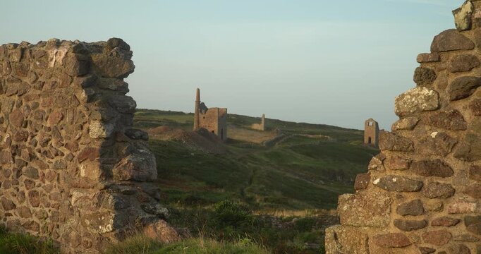 Old stone ruins of engine houses at Botallack mines on the Atlantic coast of Cornwall, England, UK during golden hour at sunrise