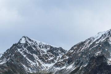 moody autumn cold day in carpathian peaks with snow on top low visibility