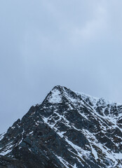 moody autumn cold day in carpathian peaks with snow on top low visibility
