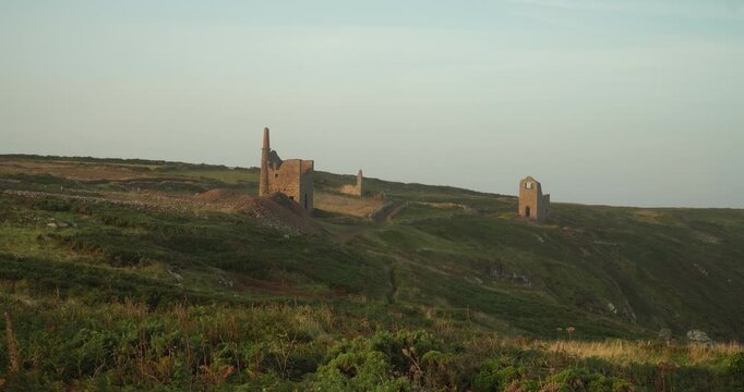 Old stone ruins of engine houses at Botallack mines on the Atlantic coast of Cornwall, England, UK during golden hour at sunrise