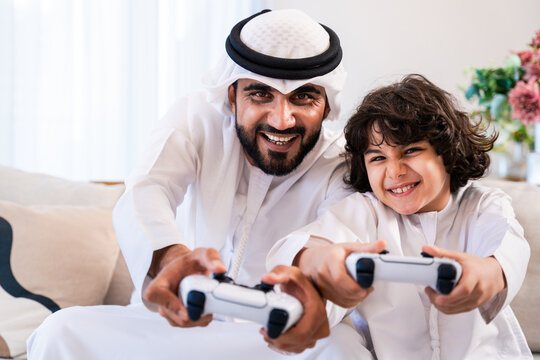 Arab father and son bonding playing video games